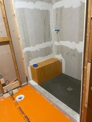A shower stall is being built in a bathroom.