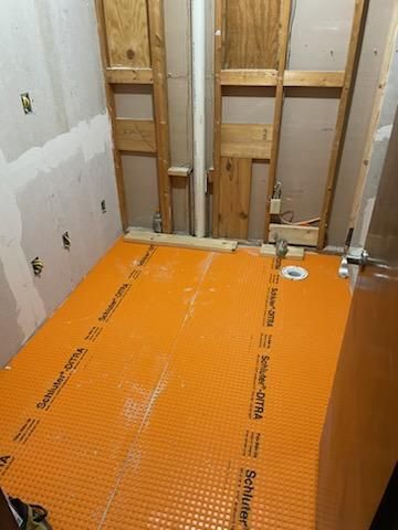A bathroom under construction with a tiled floor and wooden walls.