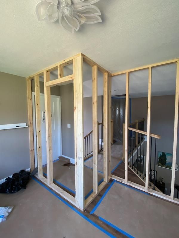 A room is being remodeled with wooden walls and a staircase.