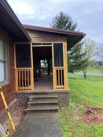 A screened in porch is being built on the side of a house.