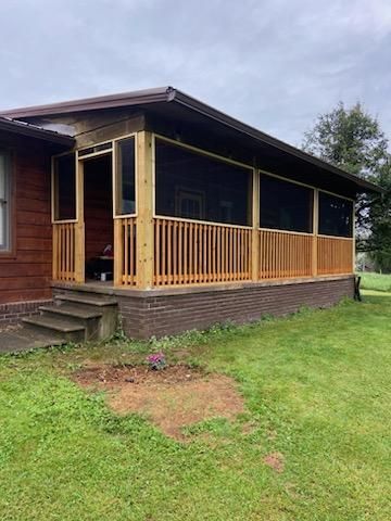There is a screened in porch on the side of a house.
