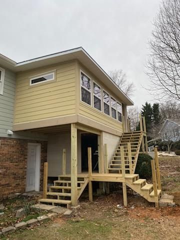 A house with a deck and stairs attached to it.
