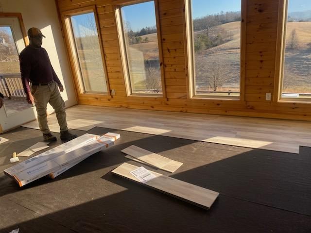 A man is standing in a room with a lot of windows.