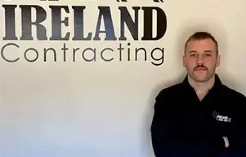 Man in black shirt stands in front of 