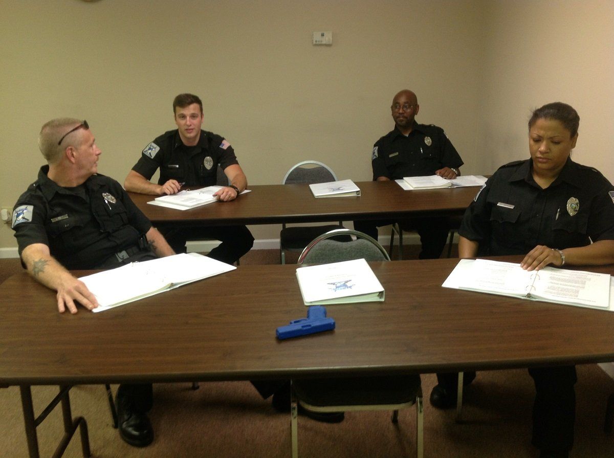 Four security officers sitting in a classroom and training
