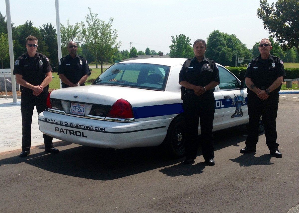 Four security guards standing around a patrol vehicle