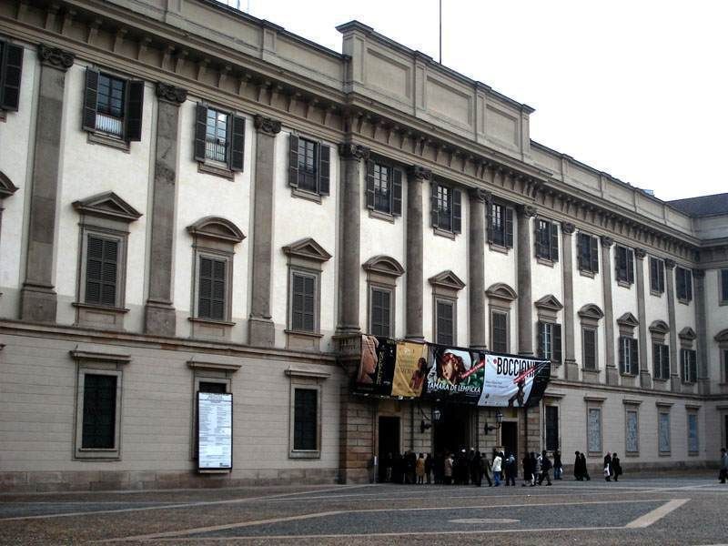 米兰王宫,新古典主义建筑风格,石墙,以及熙熙攘攘的人群正从正门进入。