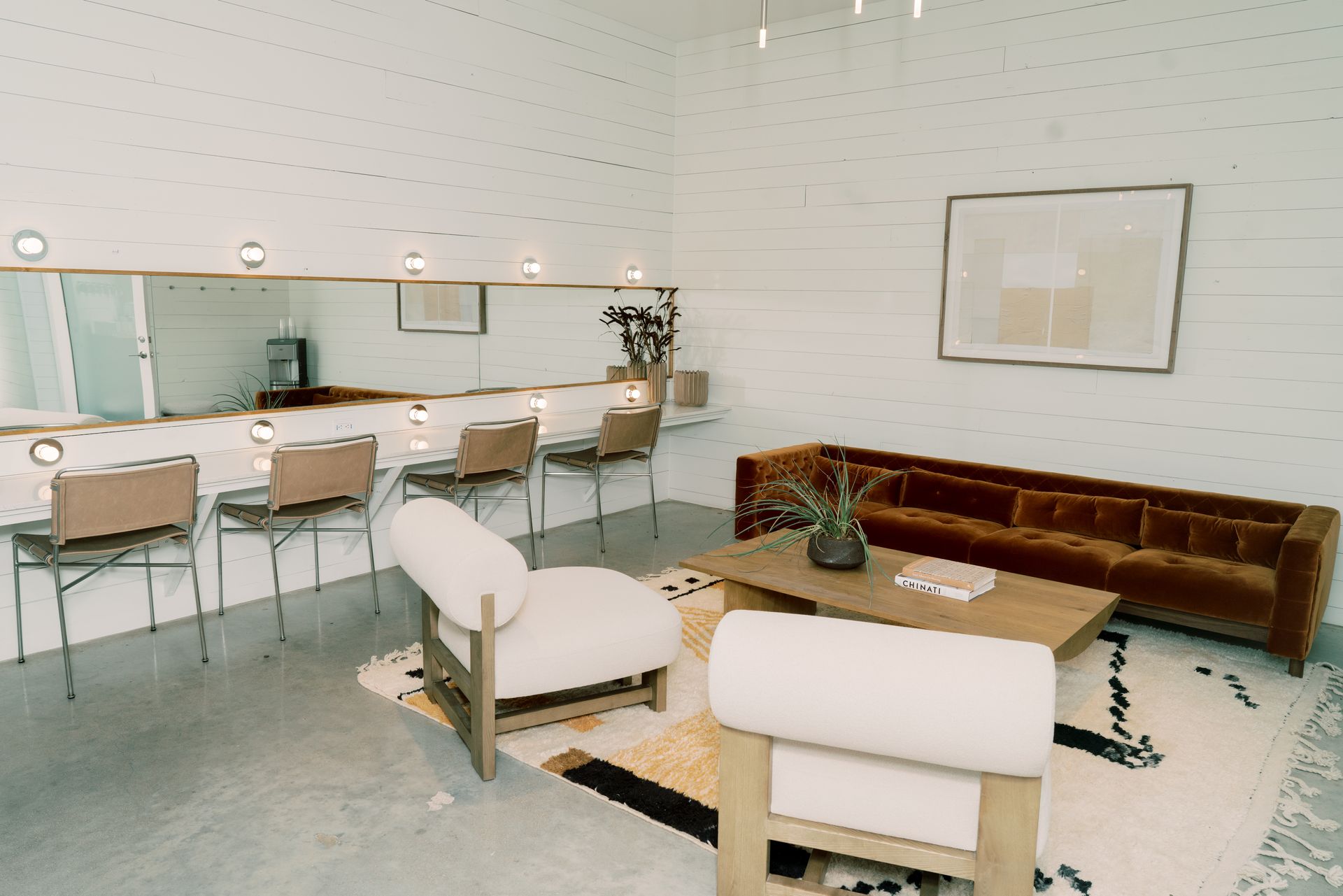 A getting ready room with vanity mirrors for hair and make up, a couch and lounge area for waiting to get your hair and make up done.