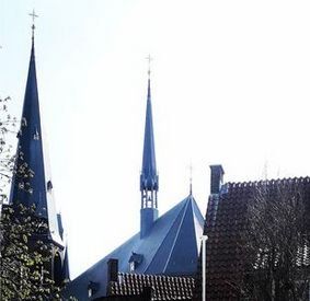 Een kerk met twee torenspitsen en een kruis op de top