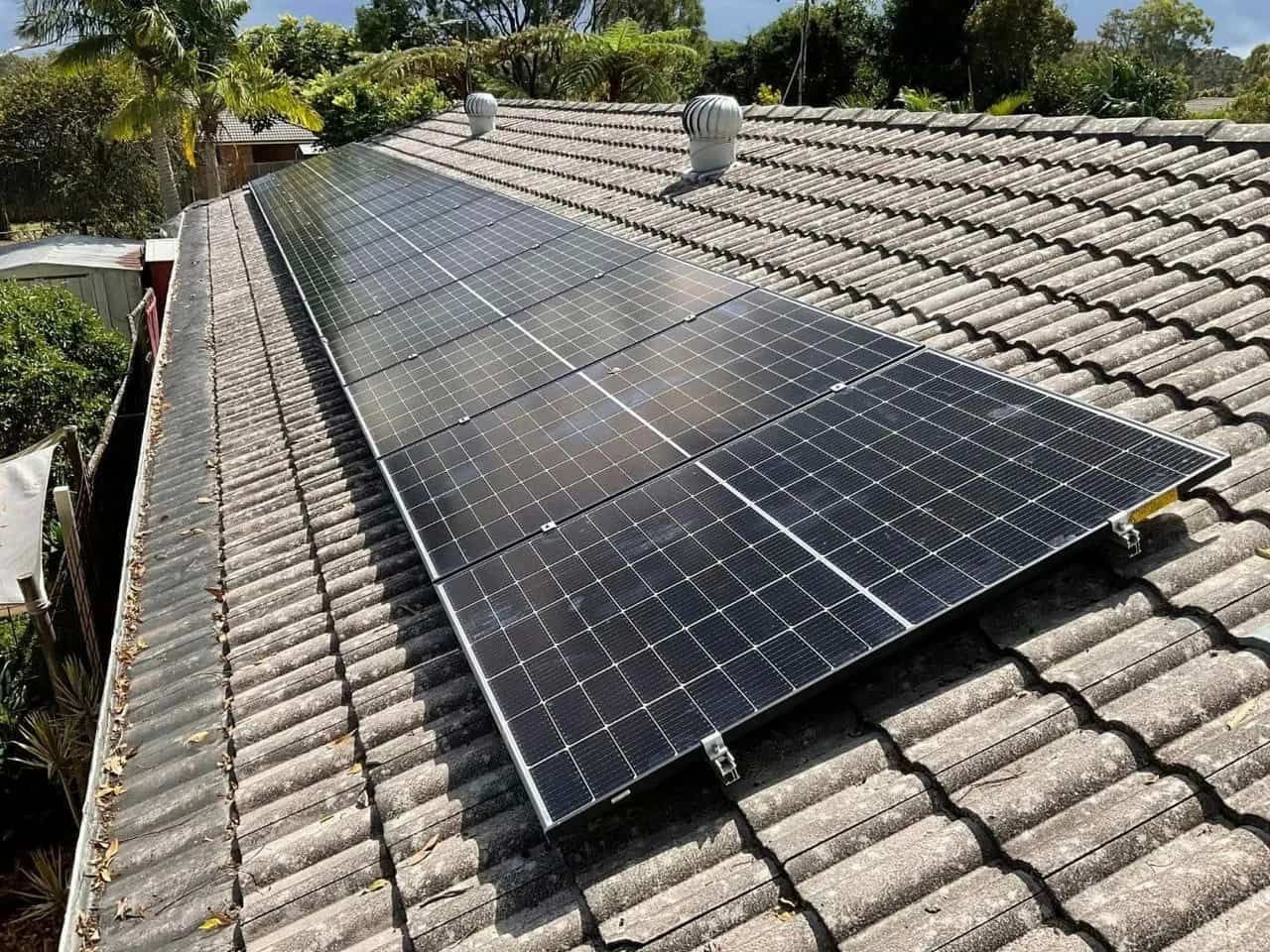 A Row of Solar Panels Sitting on Top of A Tiled Roof — Brent Hawe Solar & Electrical in Glenfield Park, NSW