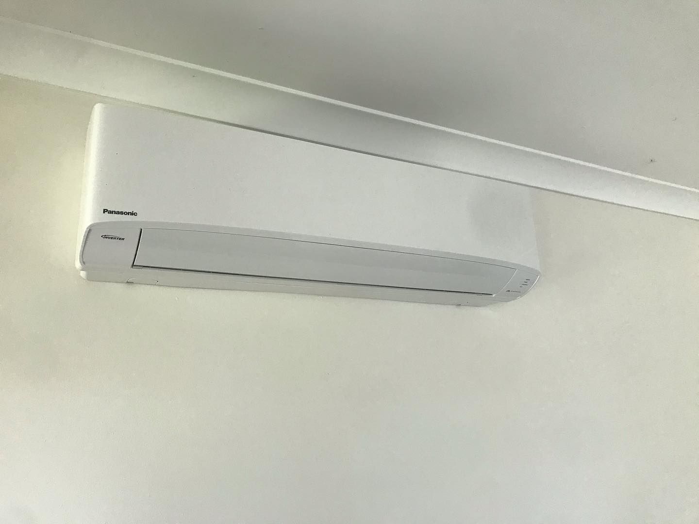 White Air Conditioner is Hanging on a White Wall — Coolman Airconditioning in Broken Head, NSW