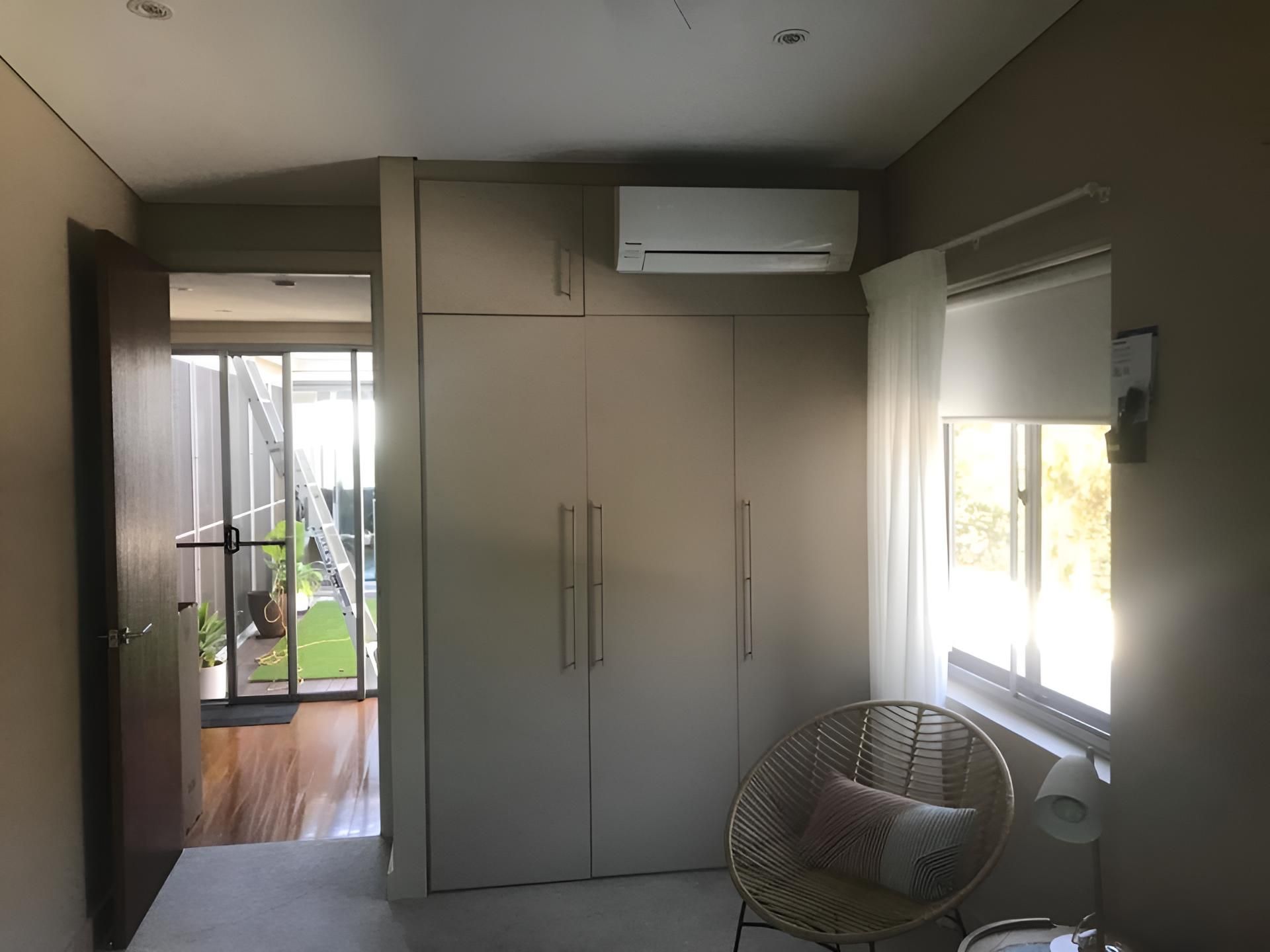 Bedroom With a Wicker Chair and Air-condition — Coolman Airconditioning in Broken Head, NSW