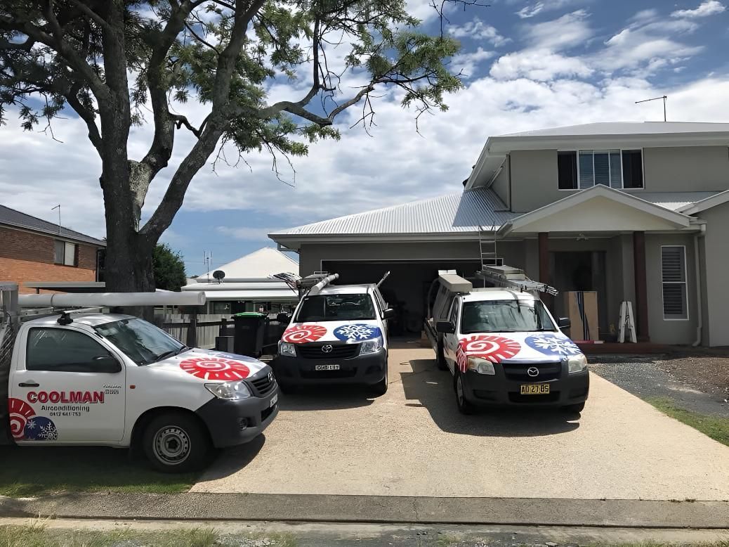 Three Vans Are Parked in Front of a House — Coolman Airconditioning in Broken Head, NSW