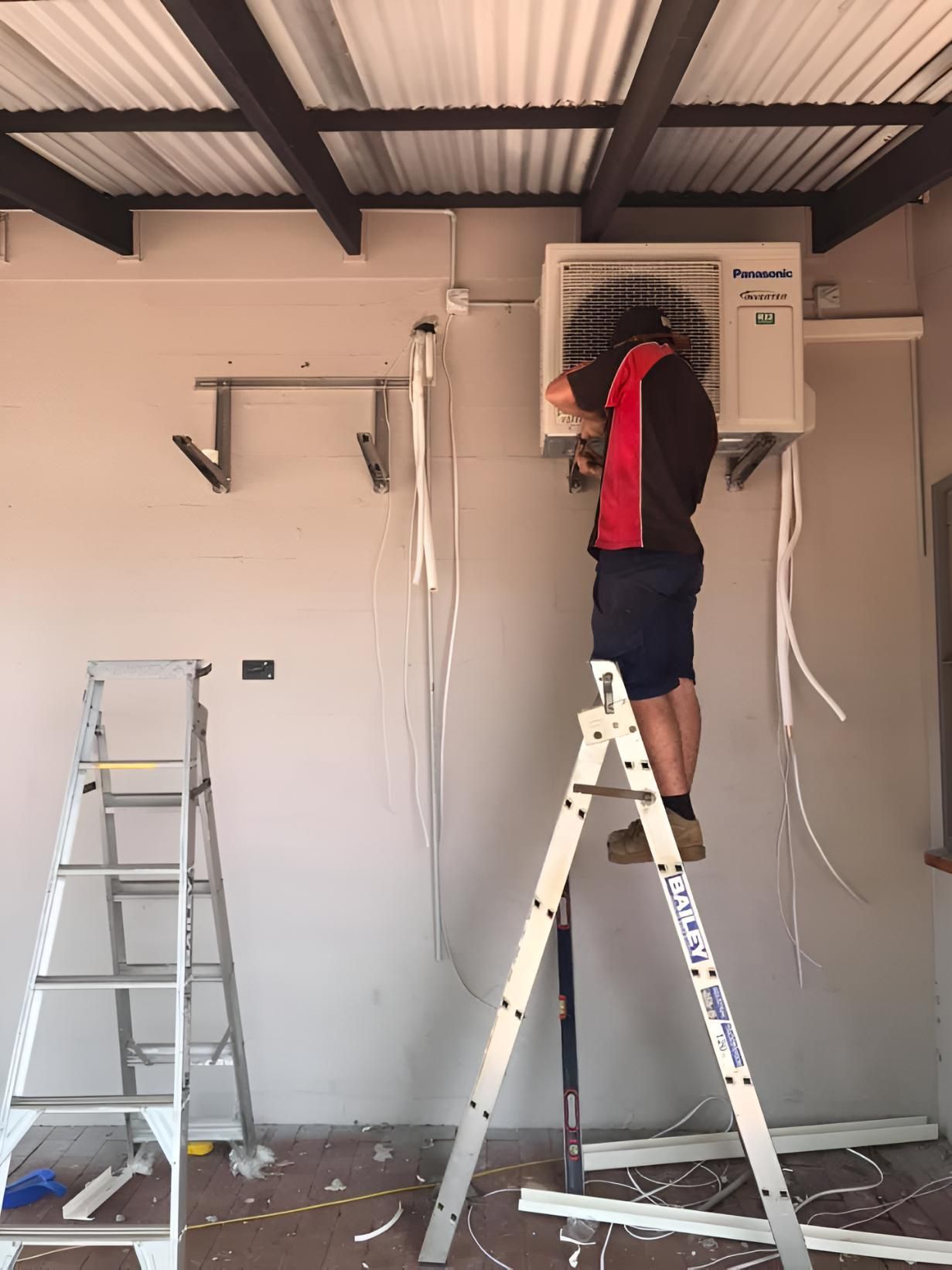 Man is on a Ladder Working on an Air Conditioner — Coolman Airconditioning in Brunswick Heads, NSW