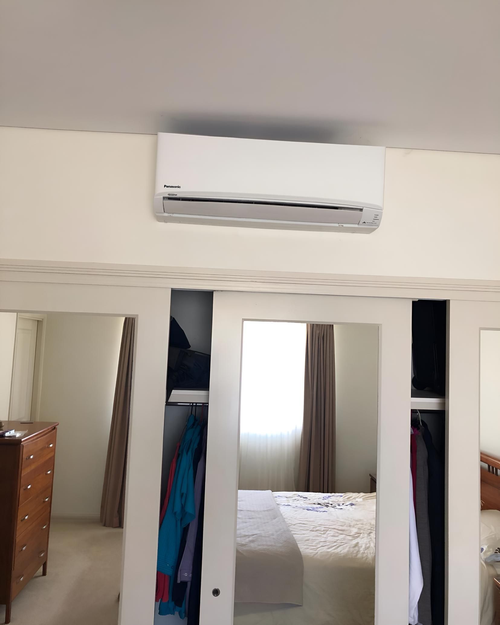 Bedroom With a Large Mirror and Air Conditioner — Coolman Airconditioning in Mullumbimby, NSW
