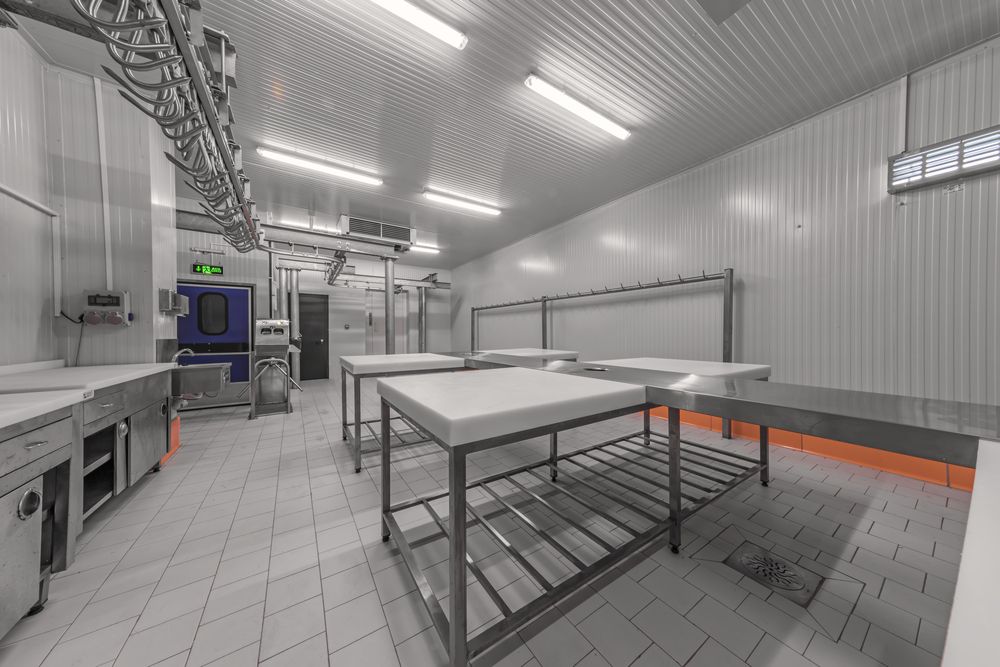 A large empty kitchen with lots of tables and counters — Coolman Airconditioning in Alstonville, NSW