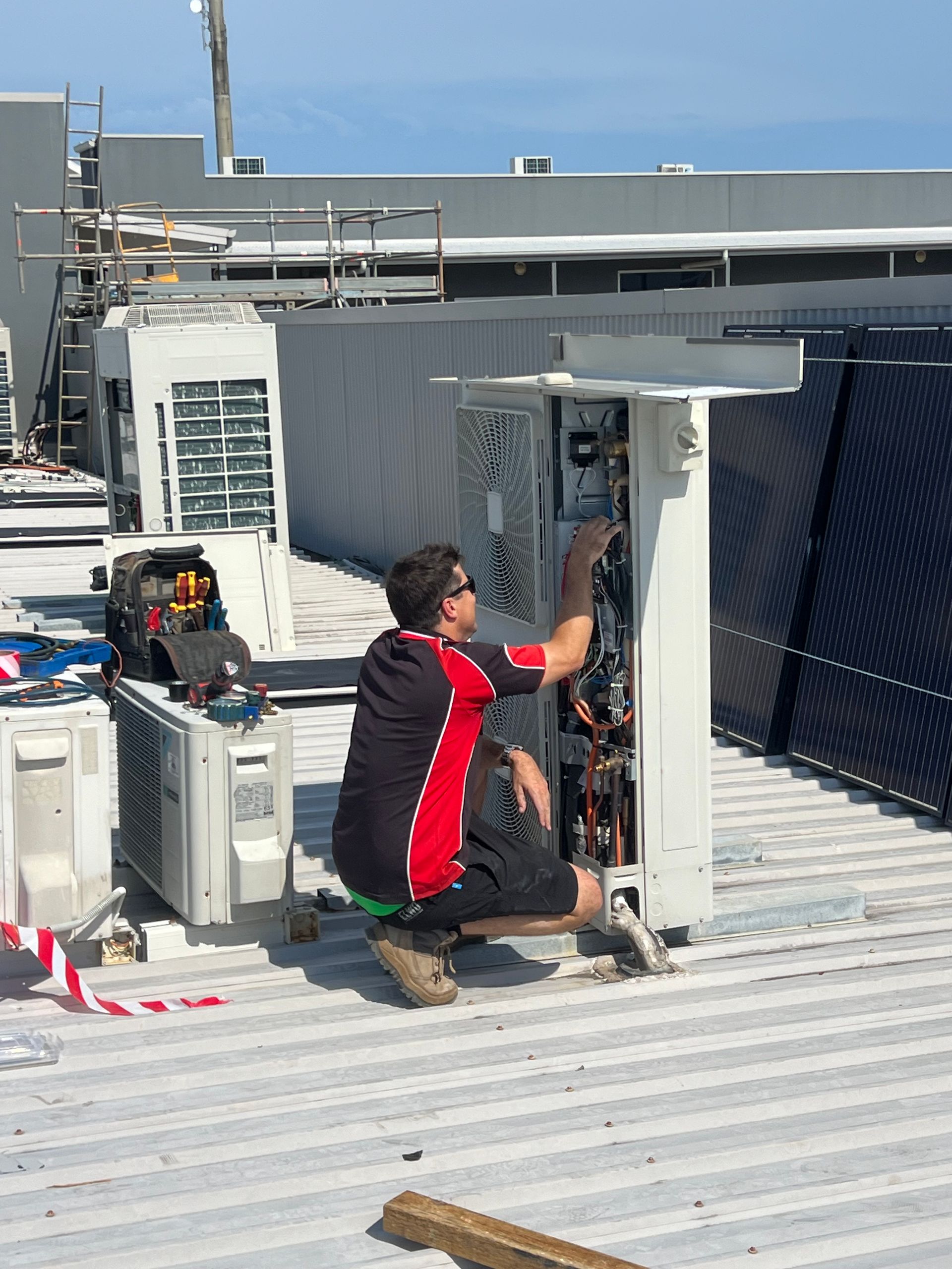 A technician maintaining a commercial air conditioning unit— Coolman Airconditioning in Ocean Shores, NSW