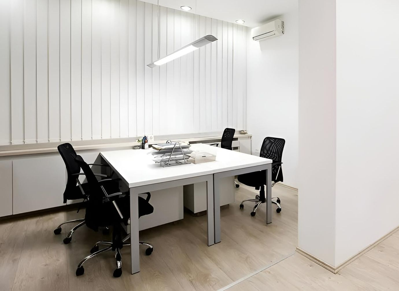Modern office space with white walls, table, and black chairs — Coolman Airconditioning in Broken Head, NSW