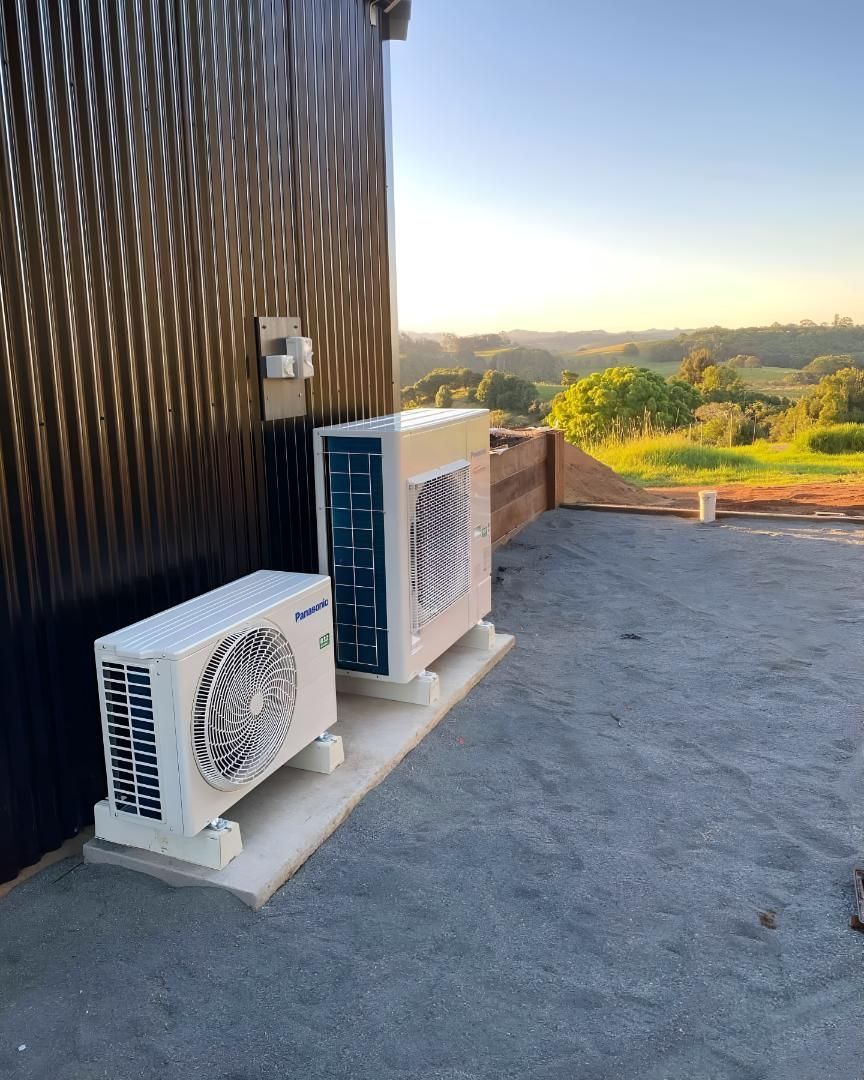 Two Air Conditioners Are Sitting on the Side of a Building — Coolman Airconditioning in Broken Head, NSW