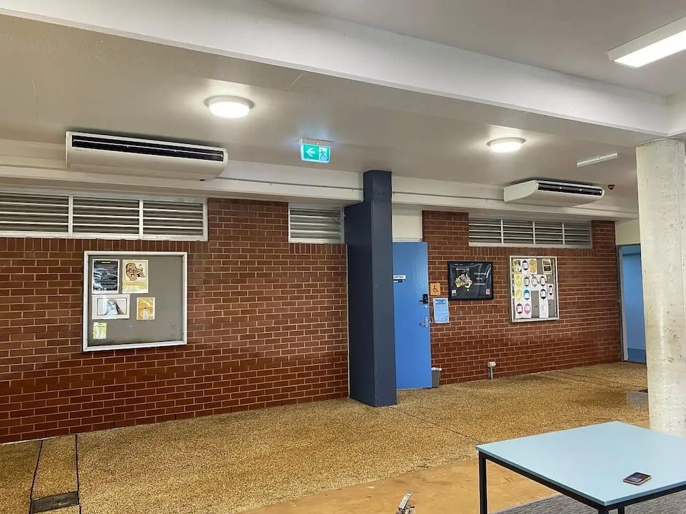 A Large Room With a Brick Wall and a Blue Door — Coolman Airconditioning in Lennox Head, NSW
