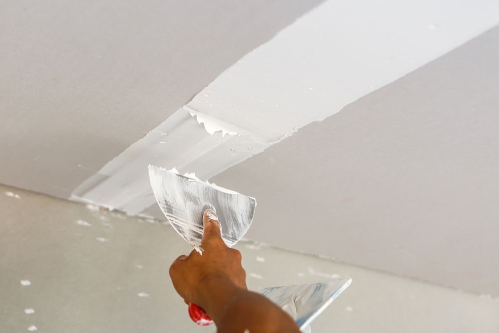 Person Applying Drywall Compound to A Ceiling with A Trowel — Completely Plastered North Coast in Lennox Head, NSW