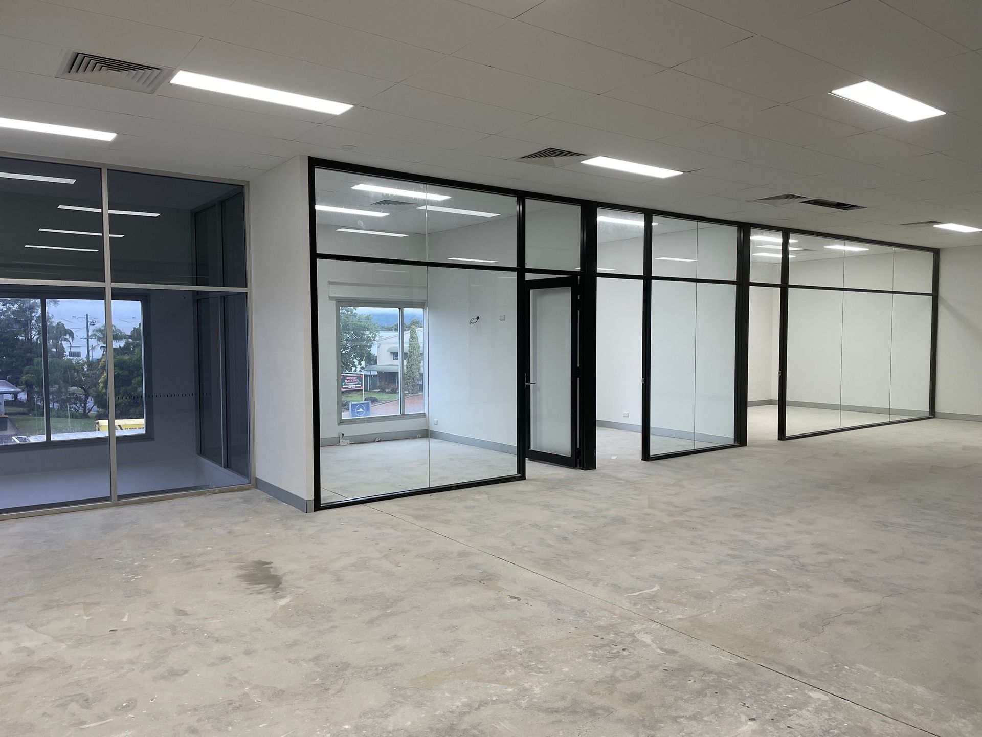 Empty Office Space with Glass and Black Metal Partitions — Completely Plastered North Coast in Lennox Head, NSW