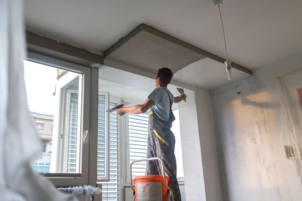 Person on A Ladder, Plastering a Ceiling with Two Trowels — Completely Plastered North Coast in Evans Head, NSW