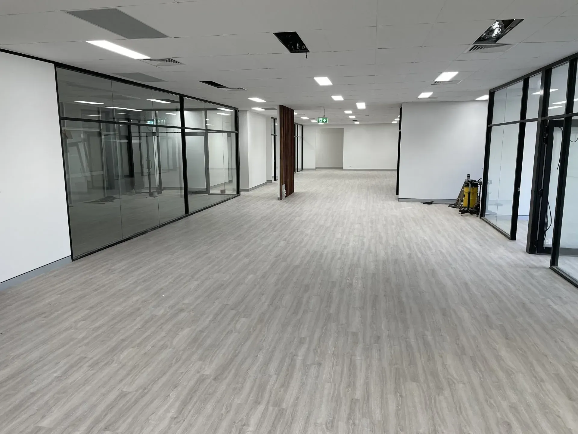 Empty Office Space with Gray Flooring and Glass Wall — Completely Plastered North Coast in Evans Head, NSW