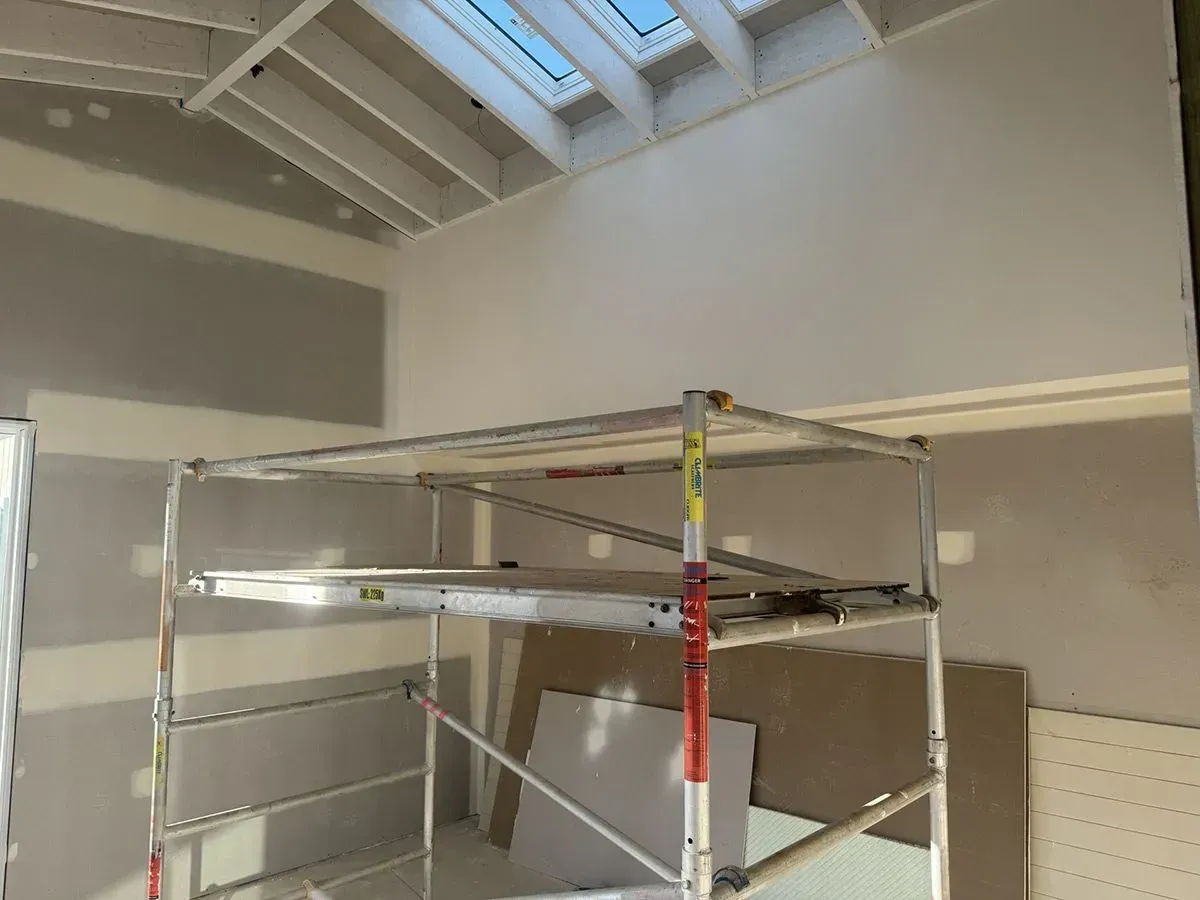Person Smoothing White Plaster on A Wall with A Trowel — Completely Plastered North Coast in Lennox Head, NSW