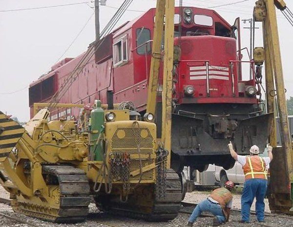 Hulcher crews and sideboom align the wheels during a wheel change out on a locomotive