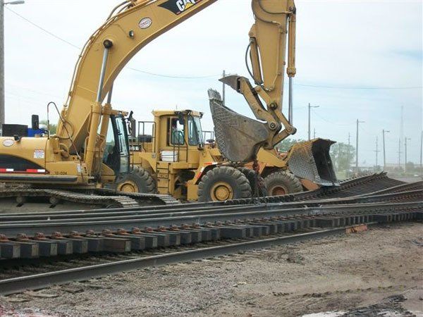 Hulcher excavator and wheel loader perform a switch change. Sidebooms, excavators and wheel loaders are all used for this type of work.