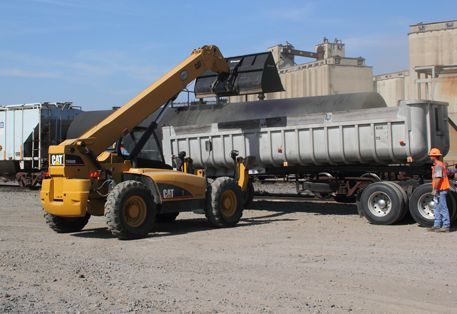 Hulcher telehandler reducting load from railcar to trucking in rail yard
.