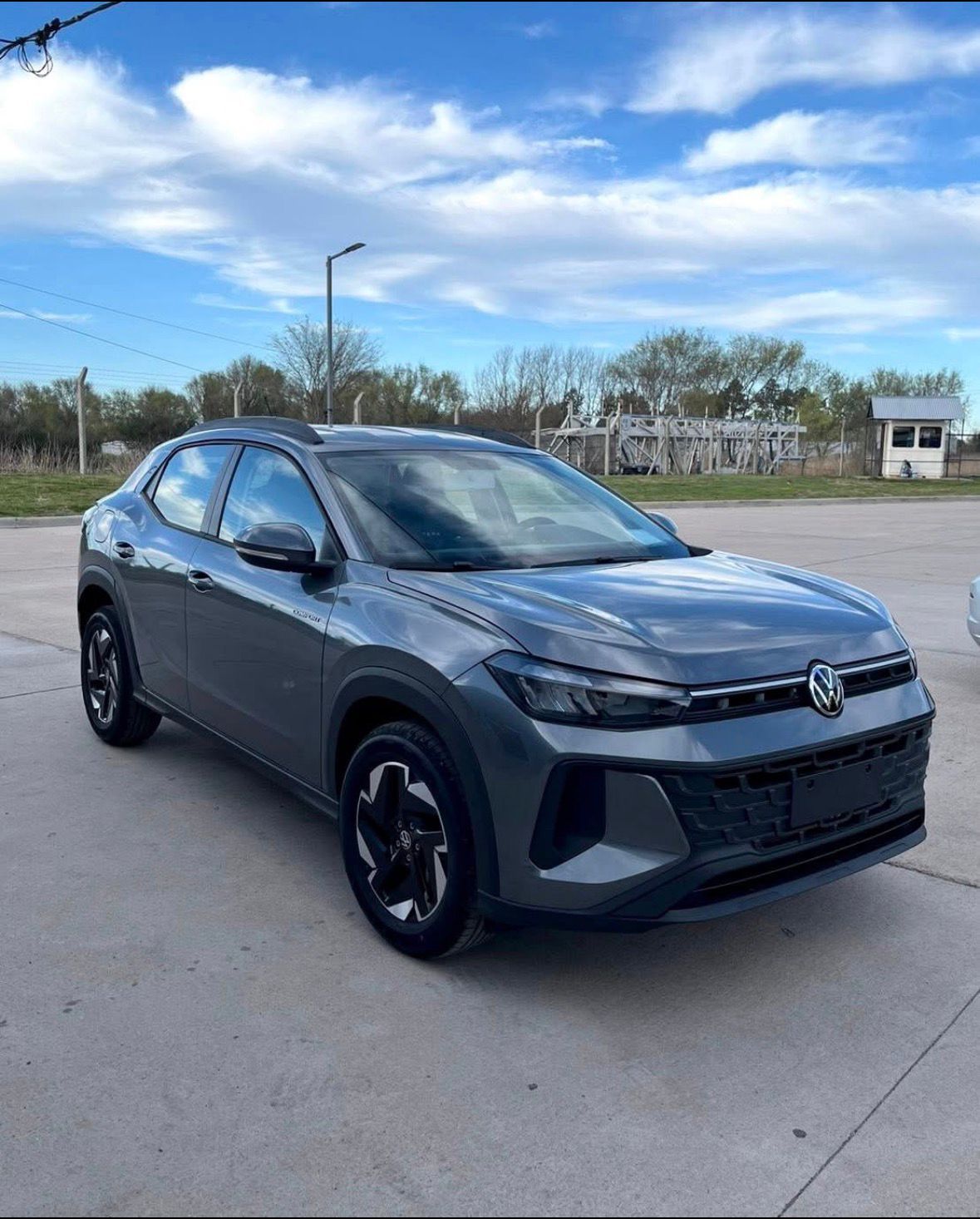 SUV Volkswagen Taigo gris estacionado sobre concreto en un día nublado.
