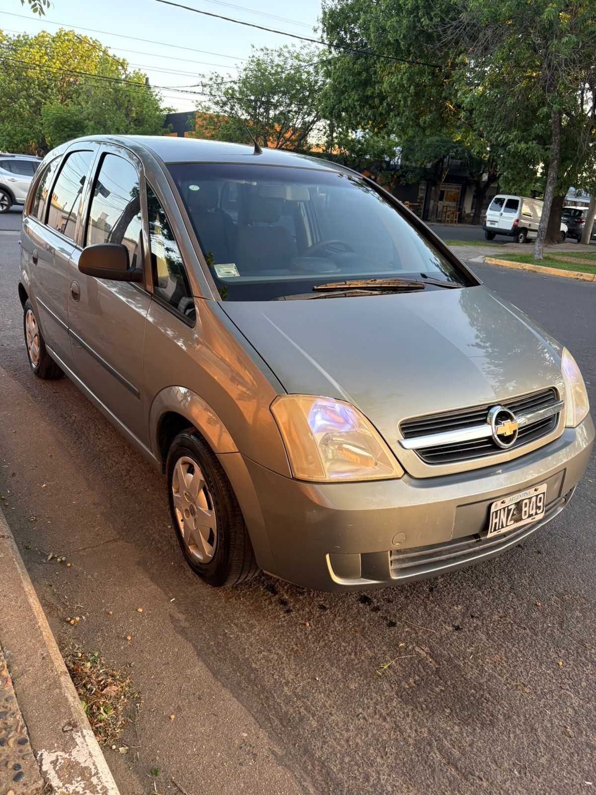 Un Opel Meriva dorado estacionado al costado de una calle.