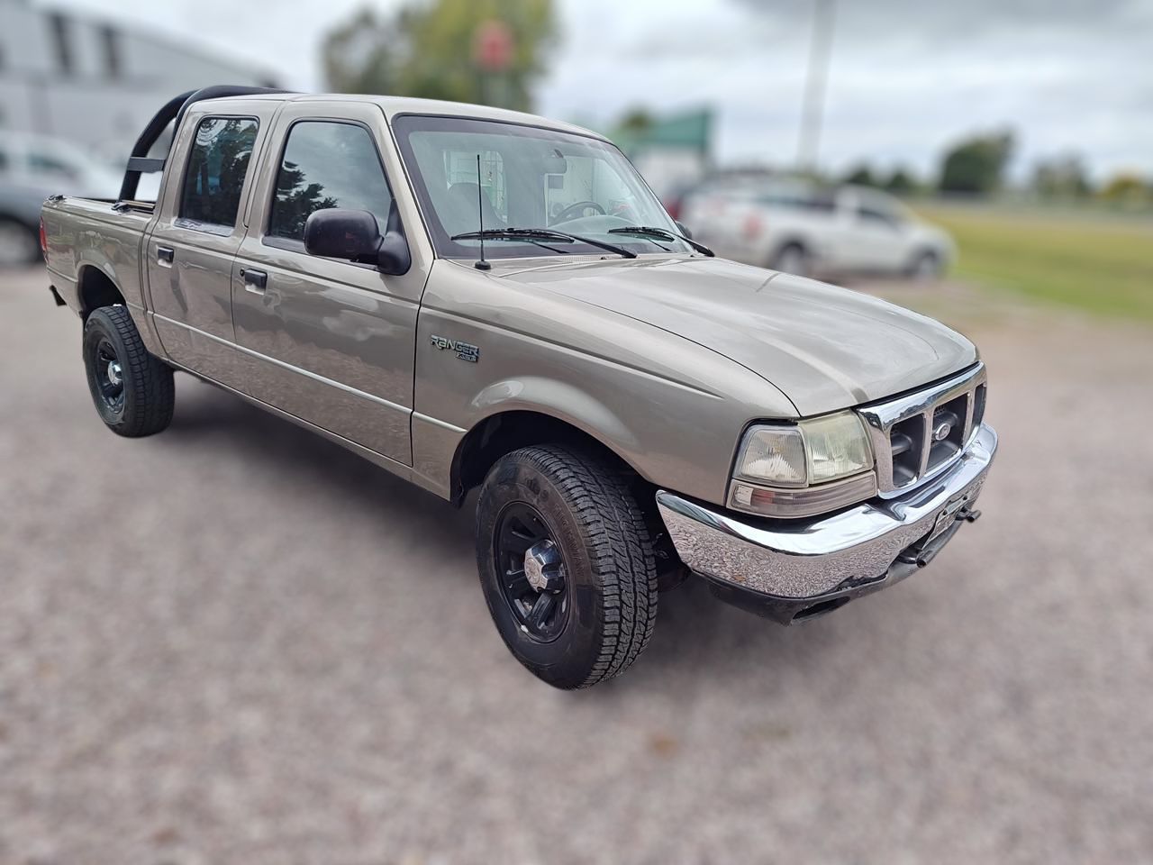 Camioneta Ford Ranger color tostado con ruedas negras, estacionada al aire libre.