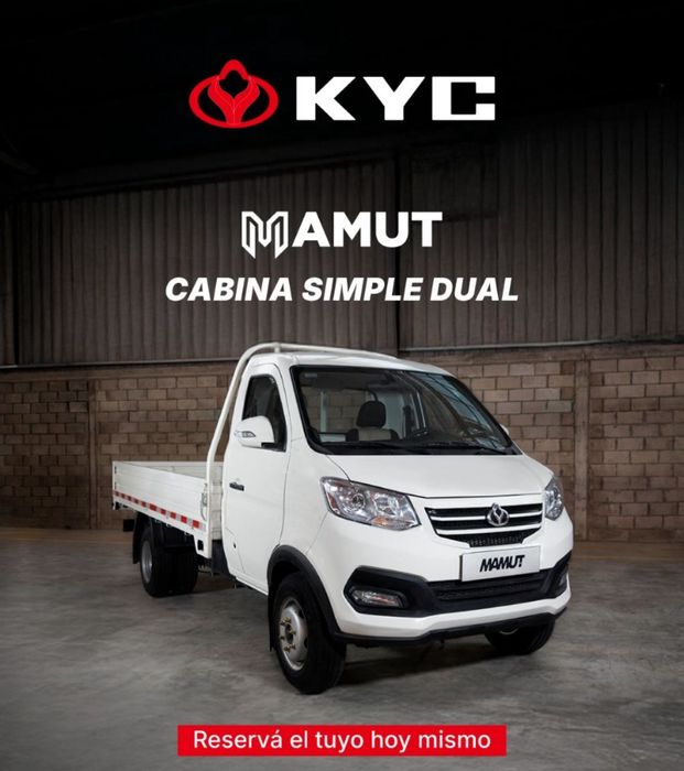 Camión Mamut KYC de color blanco, con cabina doble sencilla, estacionado en el interior de un almacén.