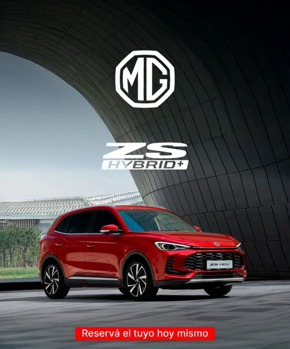 SUV MG ZS Hybrid+ rojo estacionado bajo un arco, logotipo de MG encima, texto 