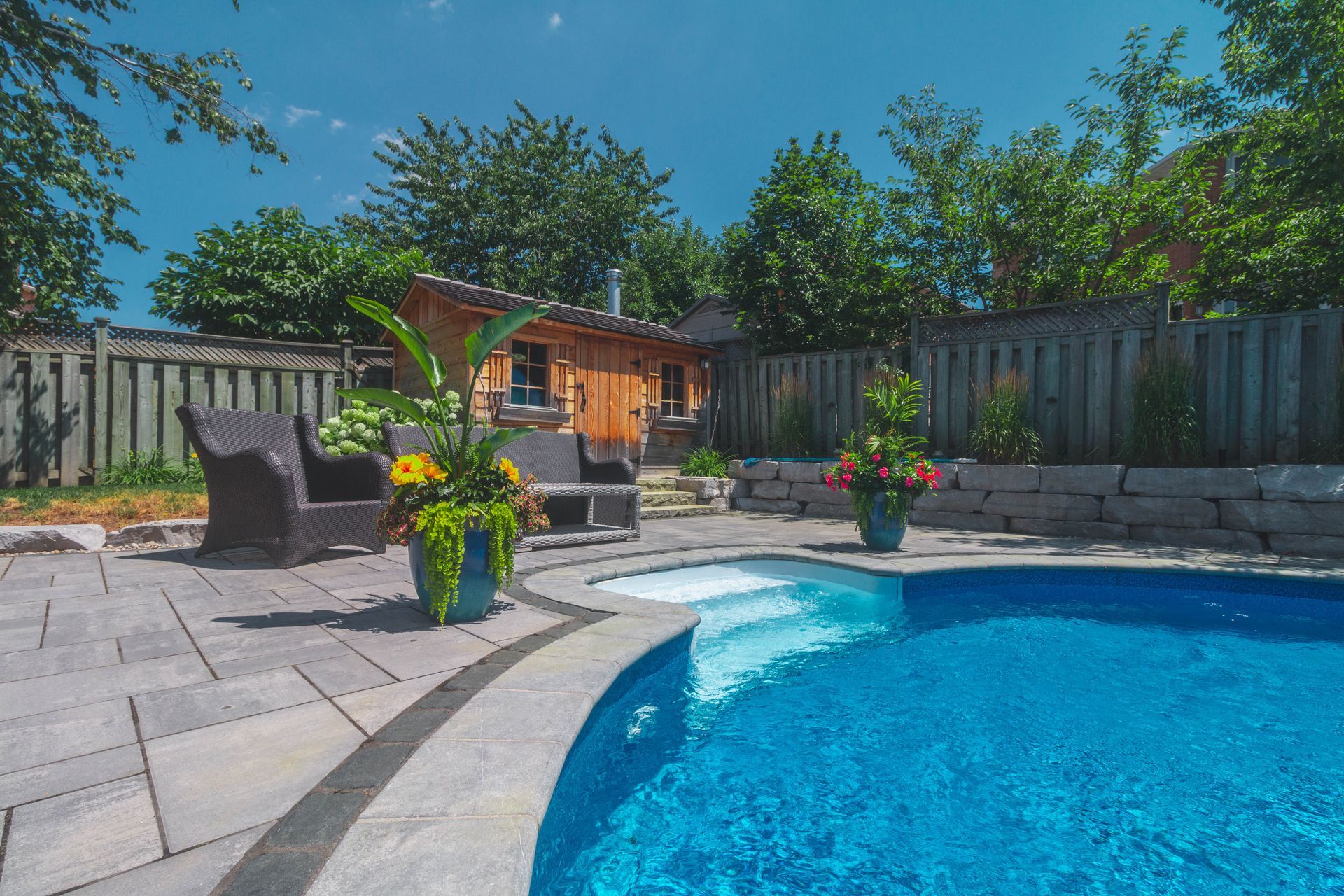 There is a large swimming pool in the backyard of a house.