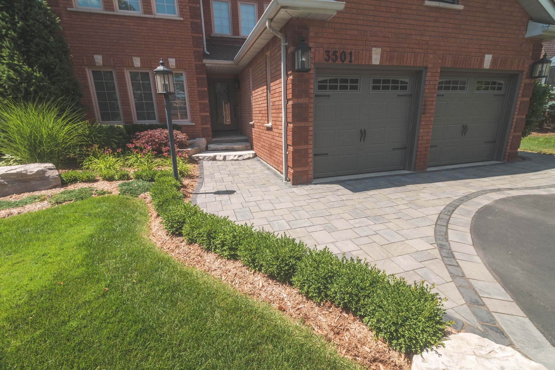 A brick house with two garage doors and a driveway