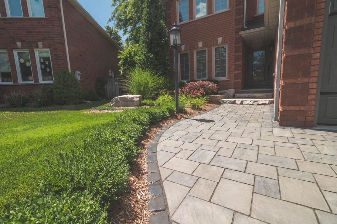 A brick house with a stone walkway leading to the front door.