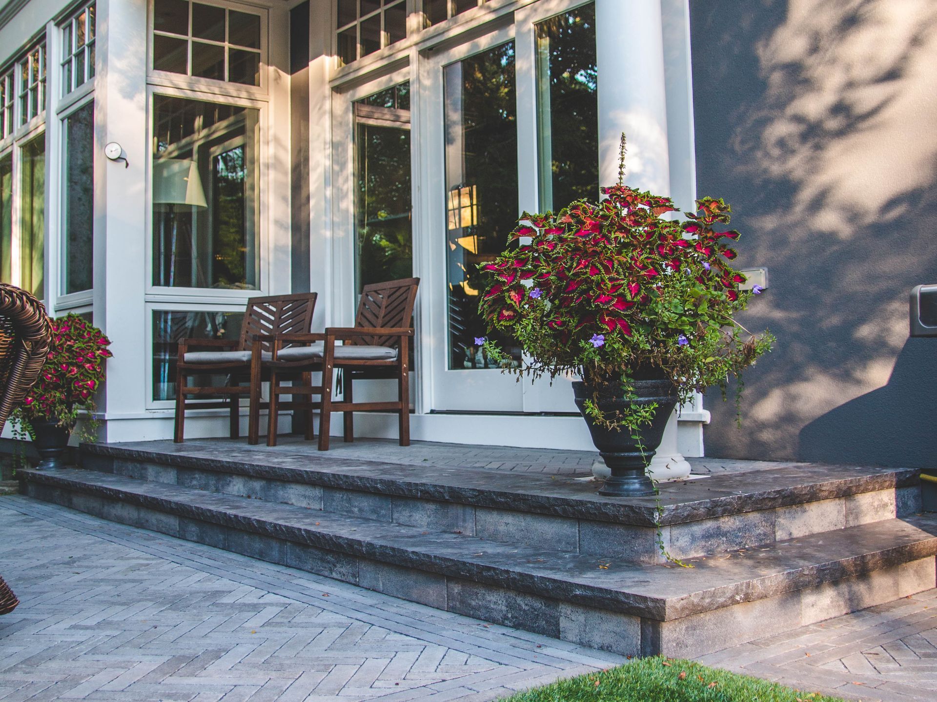 A large house with a porch and stairs leading up to it.