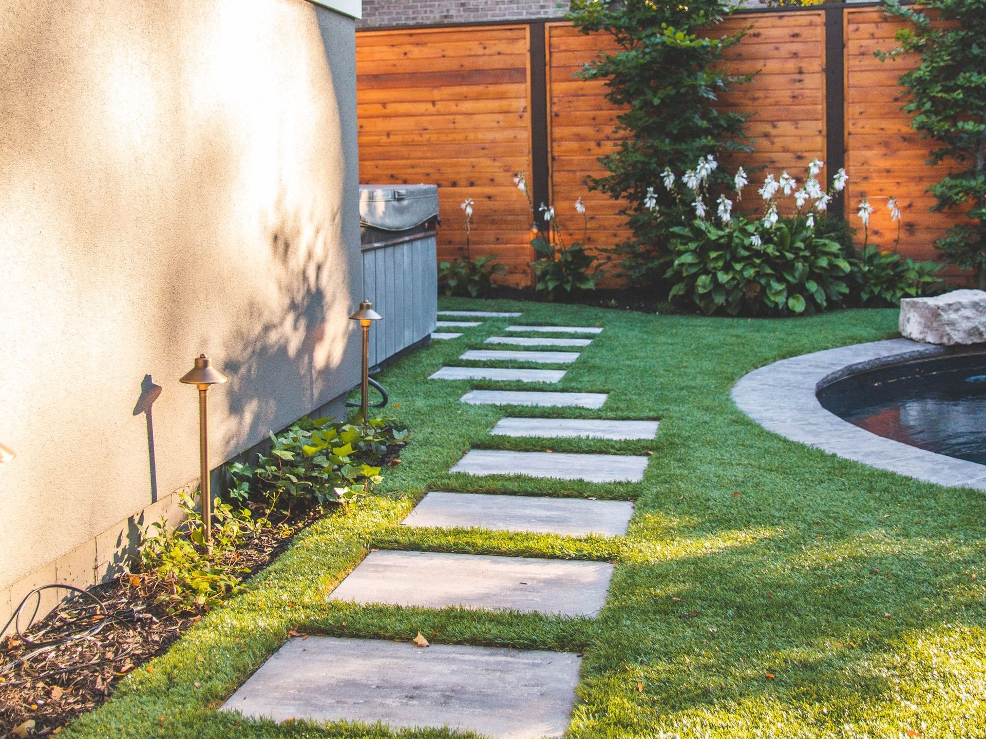 A walkway leading to a pool in a backyard