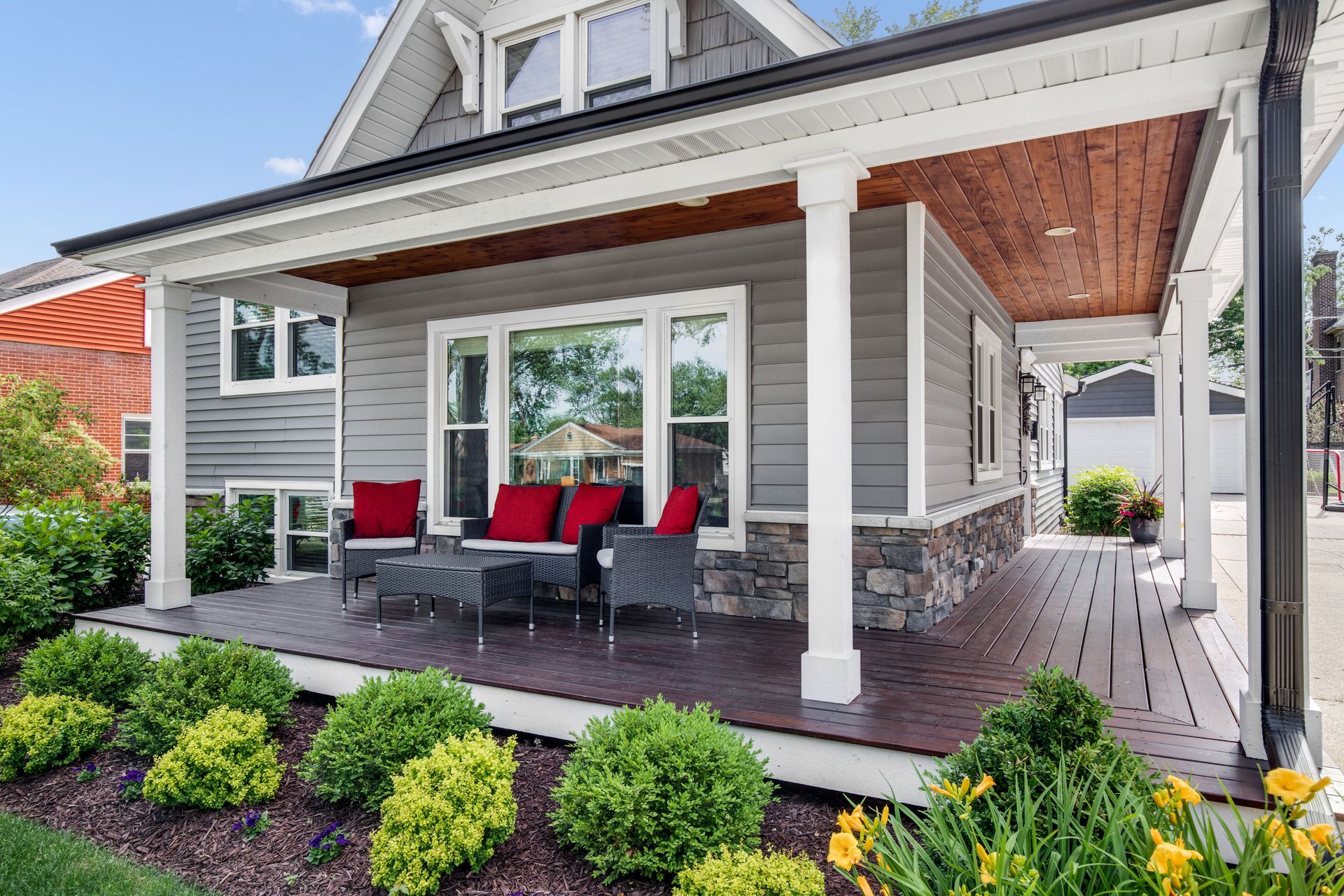 There is a porch with a couch and chairs on it.