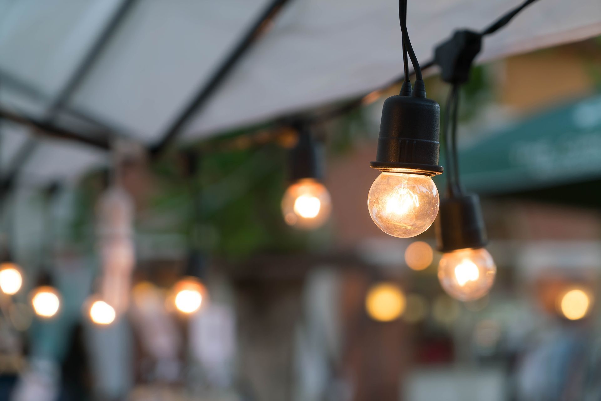 A string of light bulbs hanging from a canopy.