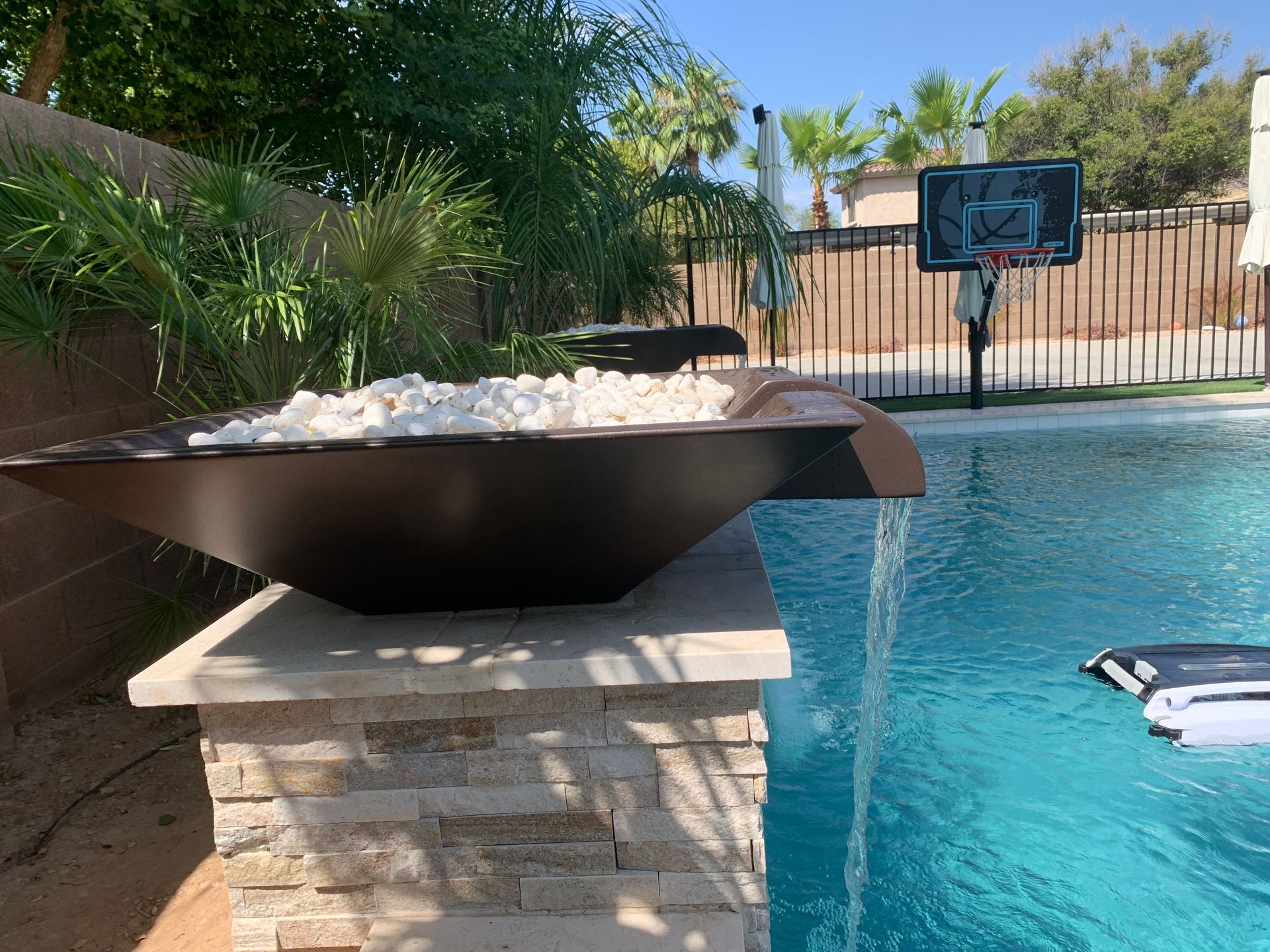 Outdoor seating area with potted plants, a patio heater, and a red wall.