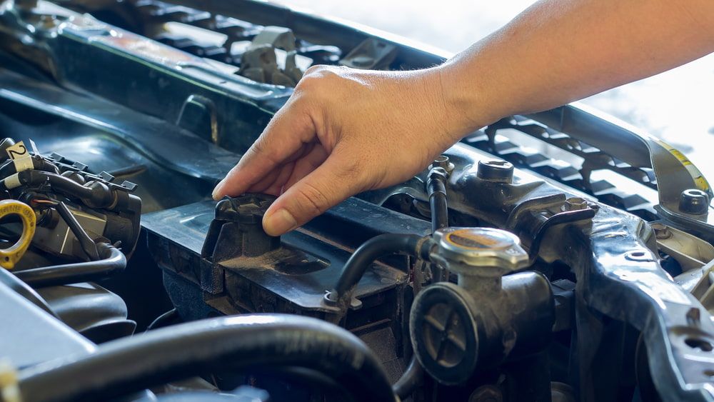 Person's Hand Opening a Car Radiator Cap in Engine Bay — The Automotive Den in Ballina, NSW