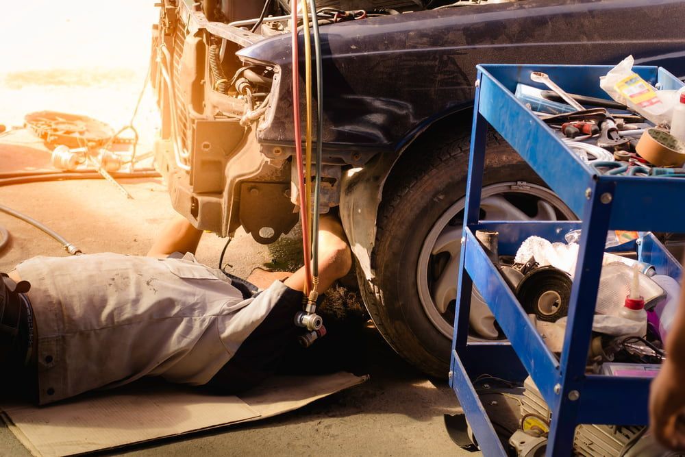 Mechanic Working Under a Car in a Garage, Tools Nearby — The Automotive Den in Ballina, NSW