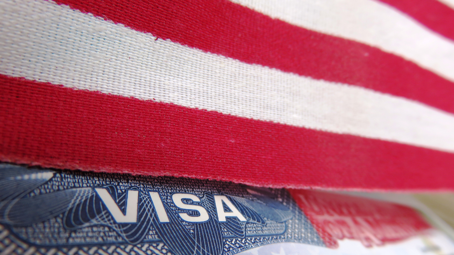 A visa is sitting on top of an american flag.