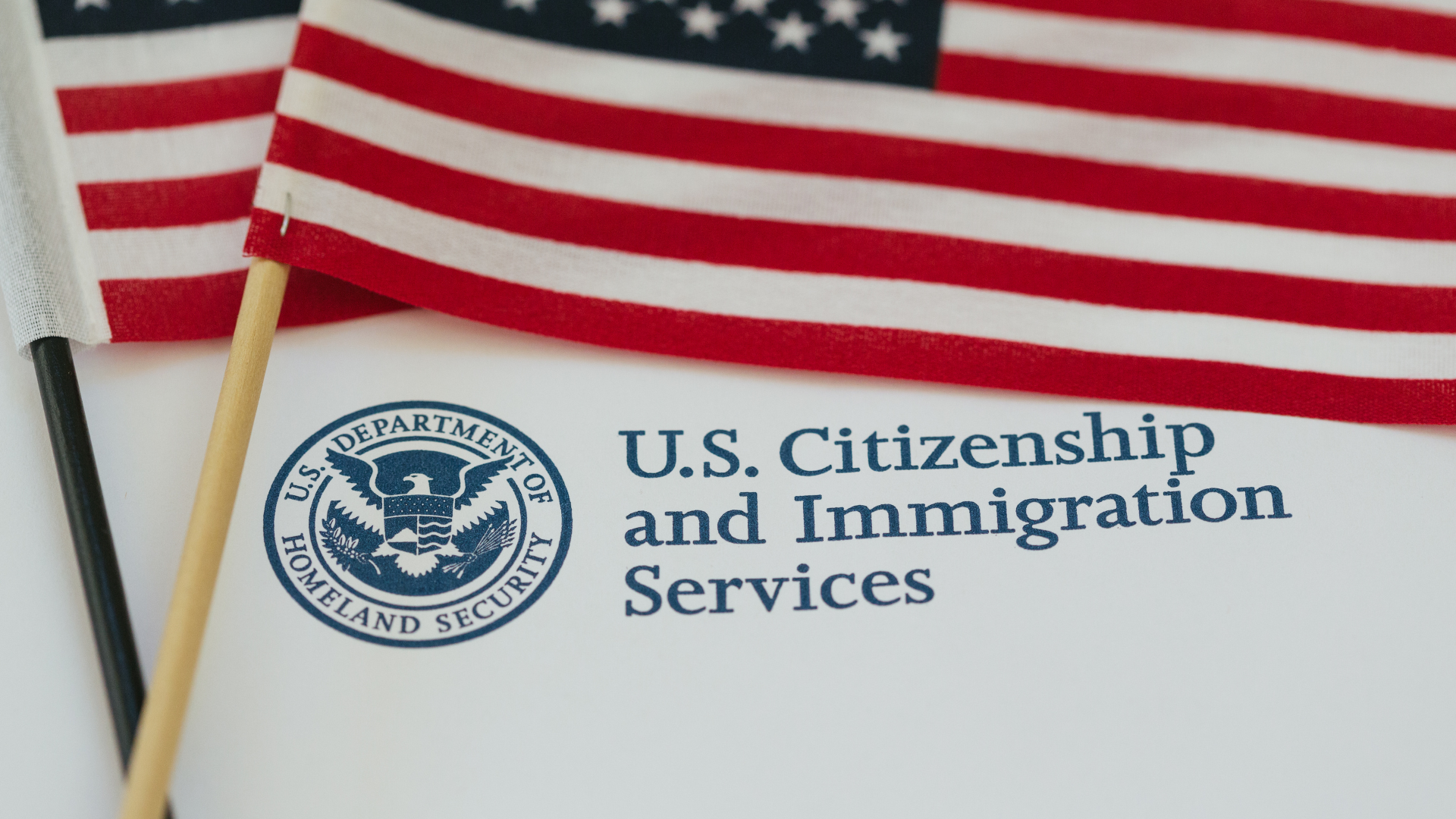 A u.s. citizenship and immigration services envelope with two flags on top of it