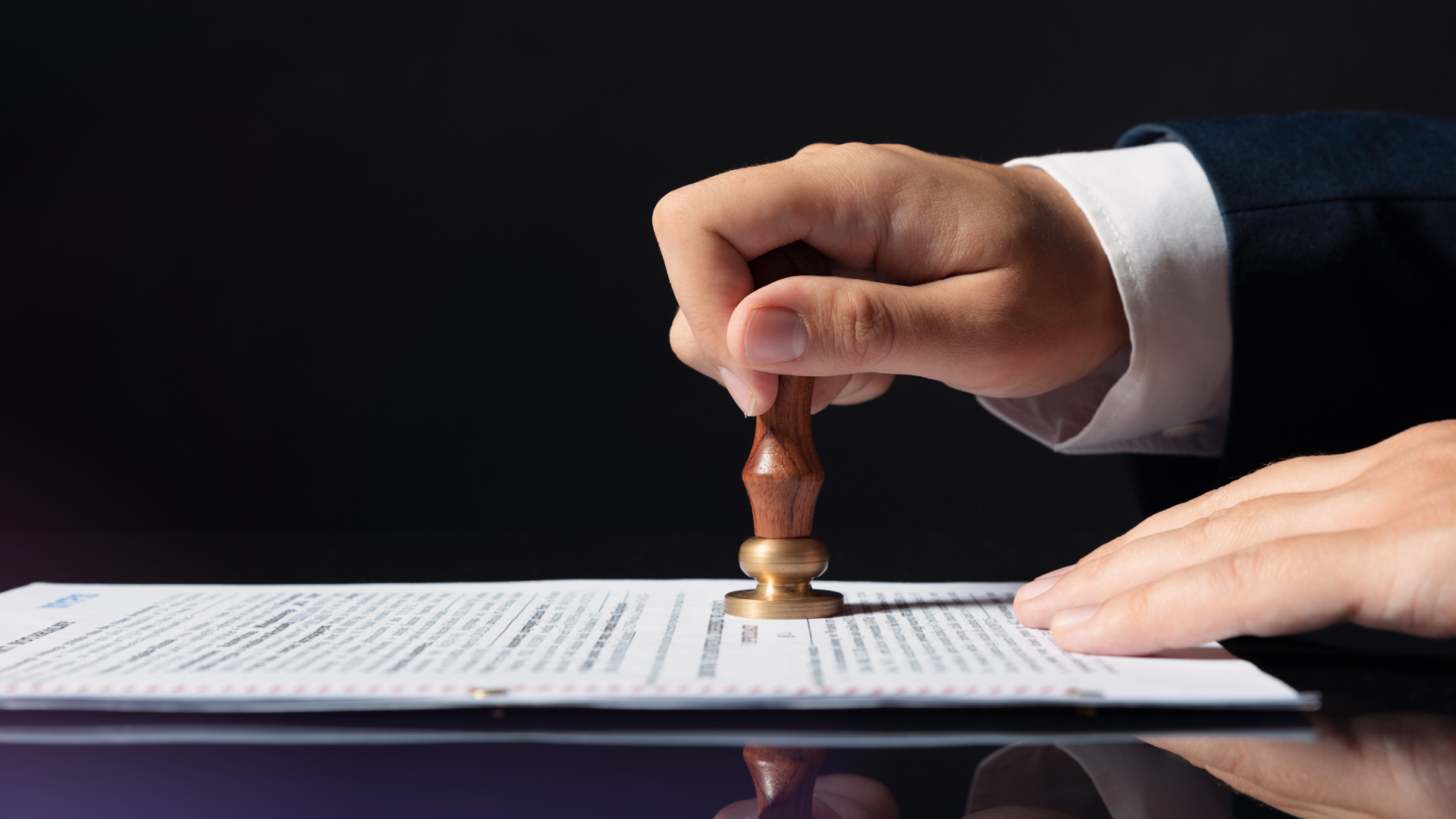 A person is stamping a document with a wax seal.